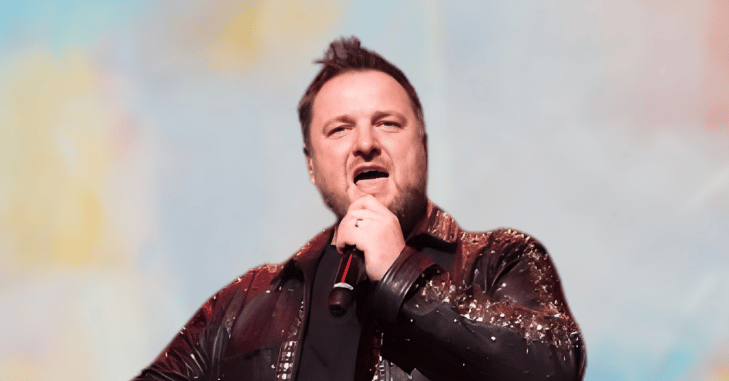 Mikey Graham performing on stage with the band
